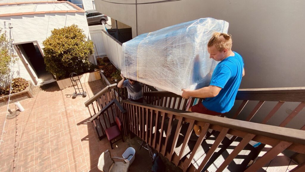professional movers lifting the couch up the stairs