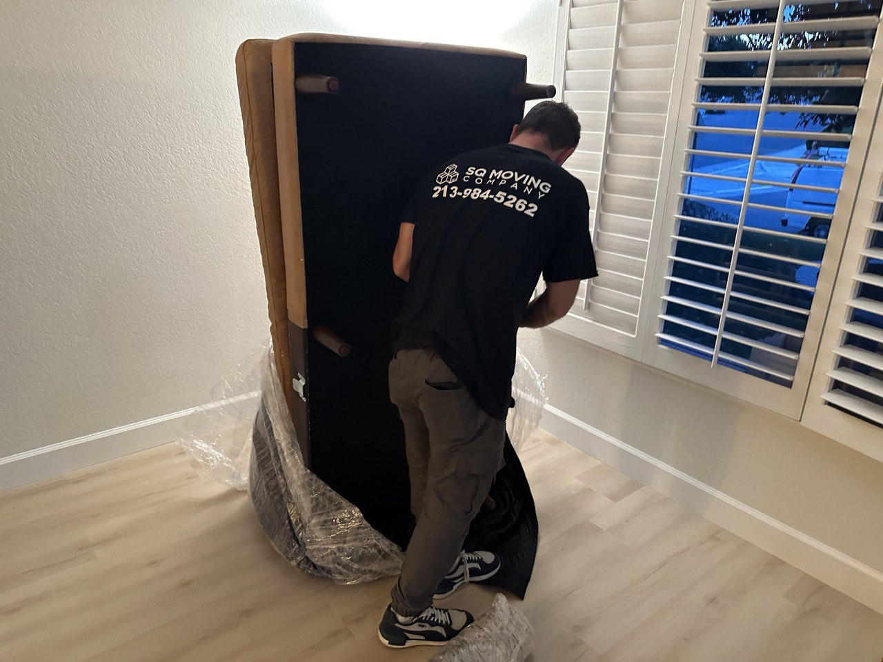 Movers in Mid City unpacking a couch during a residential move