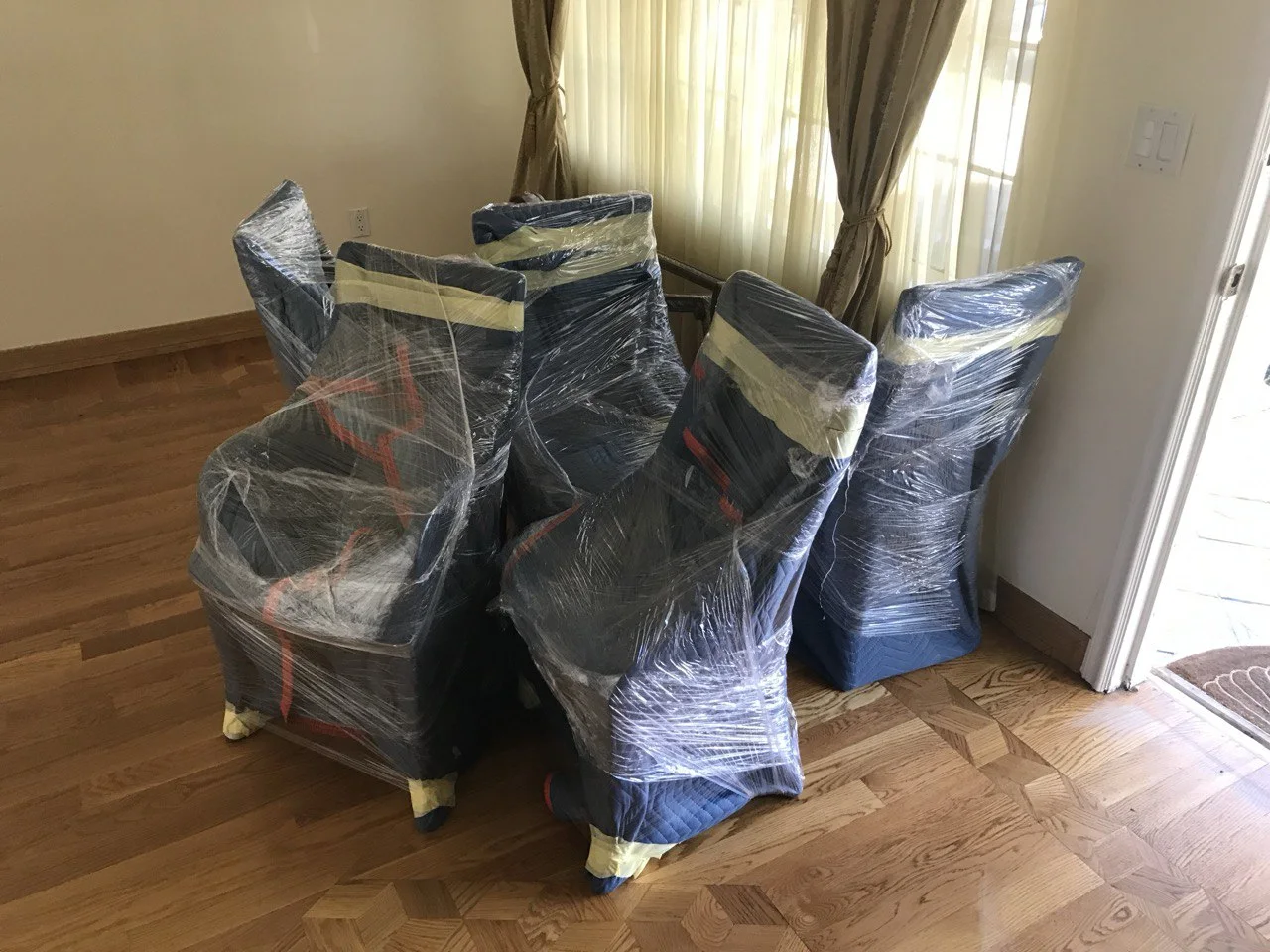Professional packing services in Sierra Madre with dining chairs wrapped and secured for transport.