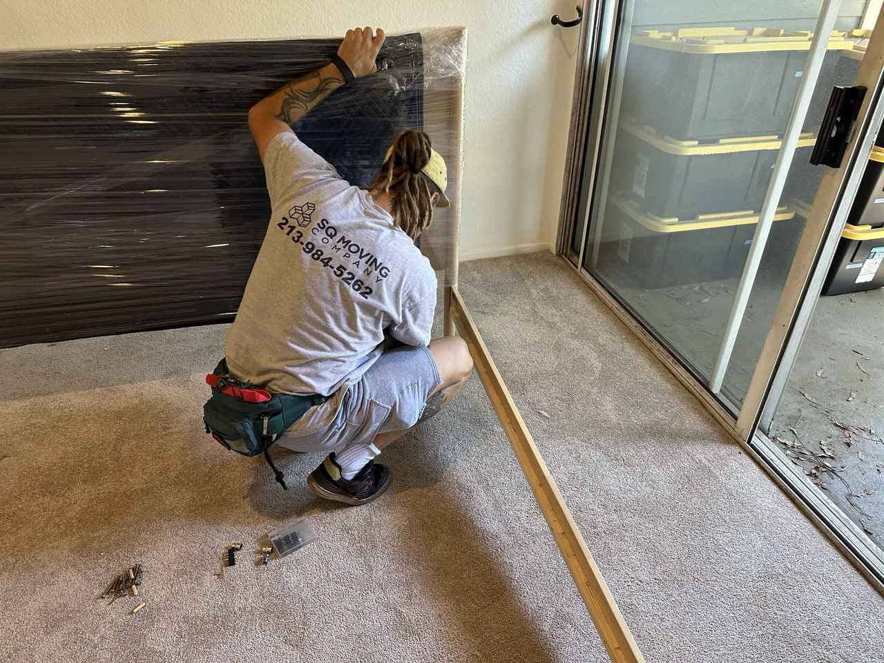 Professional Palms movers taking apart and packing a bed frame during a residential move.