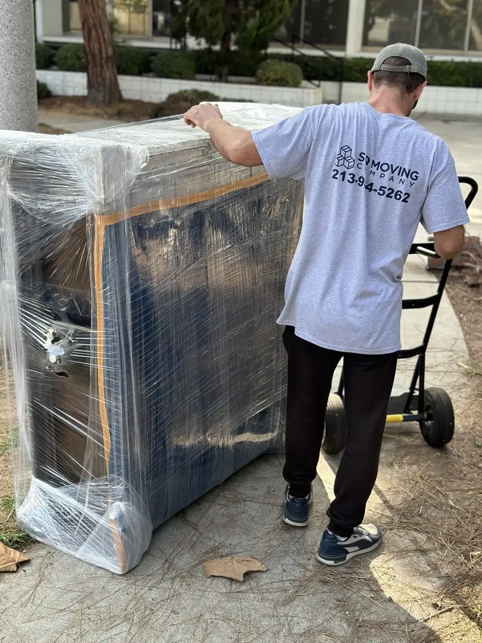 Movers in Sawtelle safely packing and moving a fully wrapped dresser during a local relocation in Sawtelle