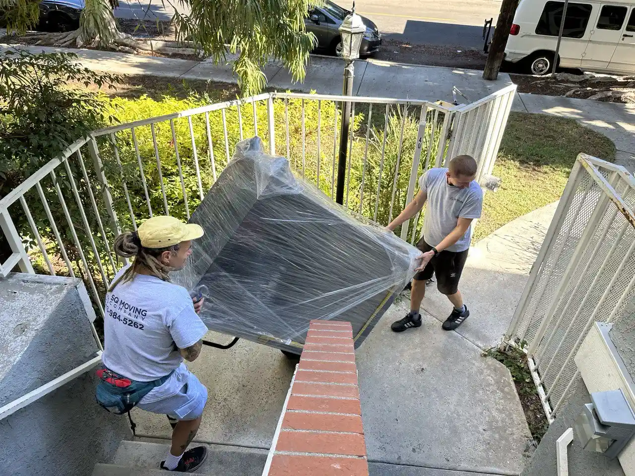 sawtelle movers carrying a fully wrapped dresser down the stairs during an apartment move in Sawtelle, Los Angeles