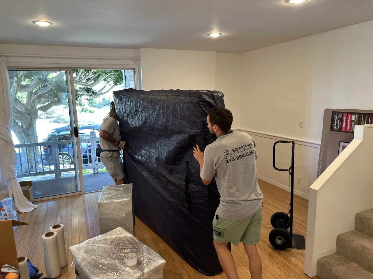 Venice Beach movers from SQ Moving Company carrying a fully protected mattress during an apartment move