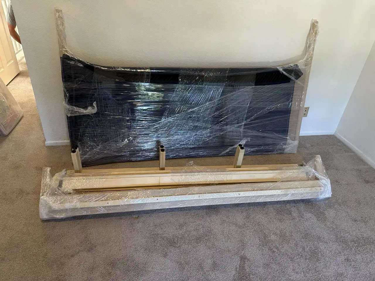 Labor-only movers disassembling and packing a wooden bed frame