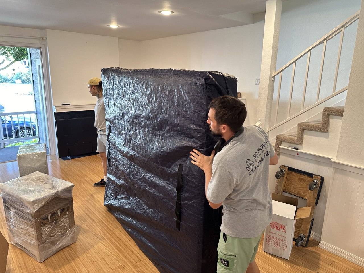 Palms movers safely packing and removing a mattress from a balcony for a residential move.