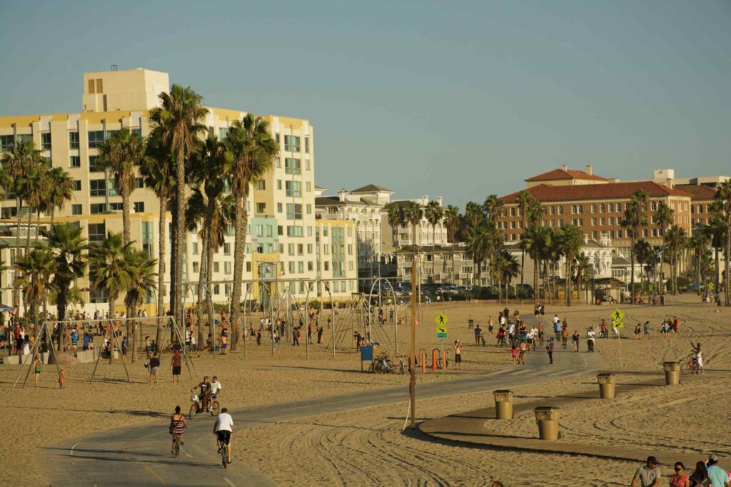 Moving to Santa Monica: Your Complete 2025 Guide to Living, Working & Thriving by the Coast 5 Outdoor activities at Santa Monica Beach with families, cyclists, and playground swings along the sand