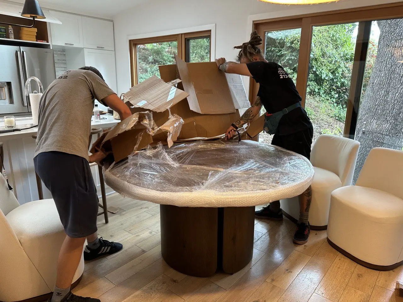 Professional labor movers unpacking and assembling furniture inside a home