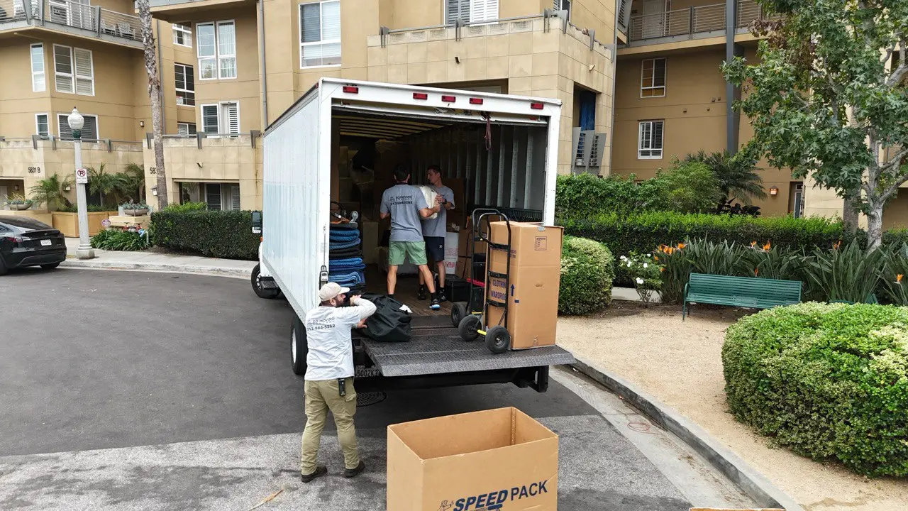 Professional Miracle Mile movers loading a moving truck with carefully protected furniture