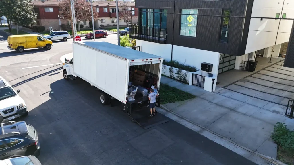 How to Prepare Furniture for Moving in LA: Step-by-Step Guide 7 Azusa moving crew loading a large box truck outside a modern townhouse complex during a neighborhood relocation
