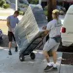 How to Prepare Furniture for Moving in LA: Step-by-Step Guide 7 Shrink-wrapped dresser secured on a hand truck | how to prepare furniture for moving