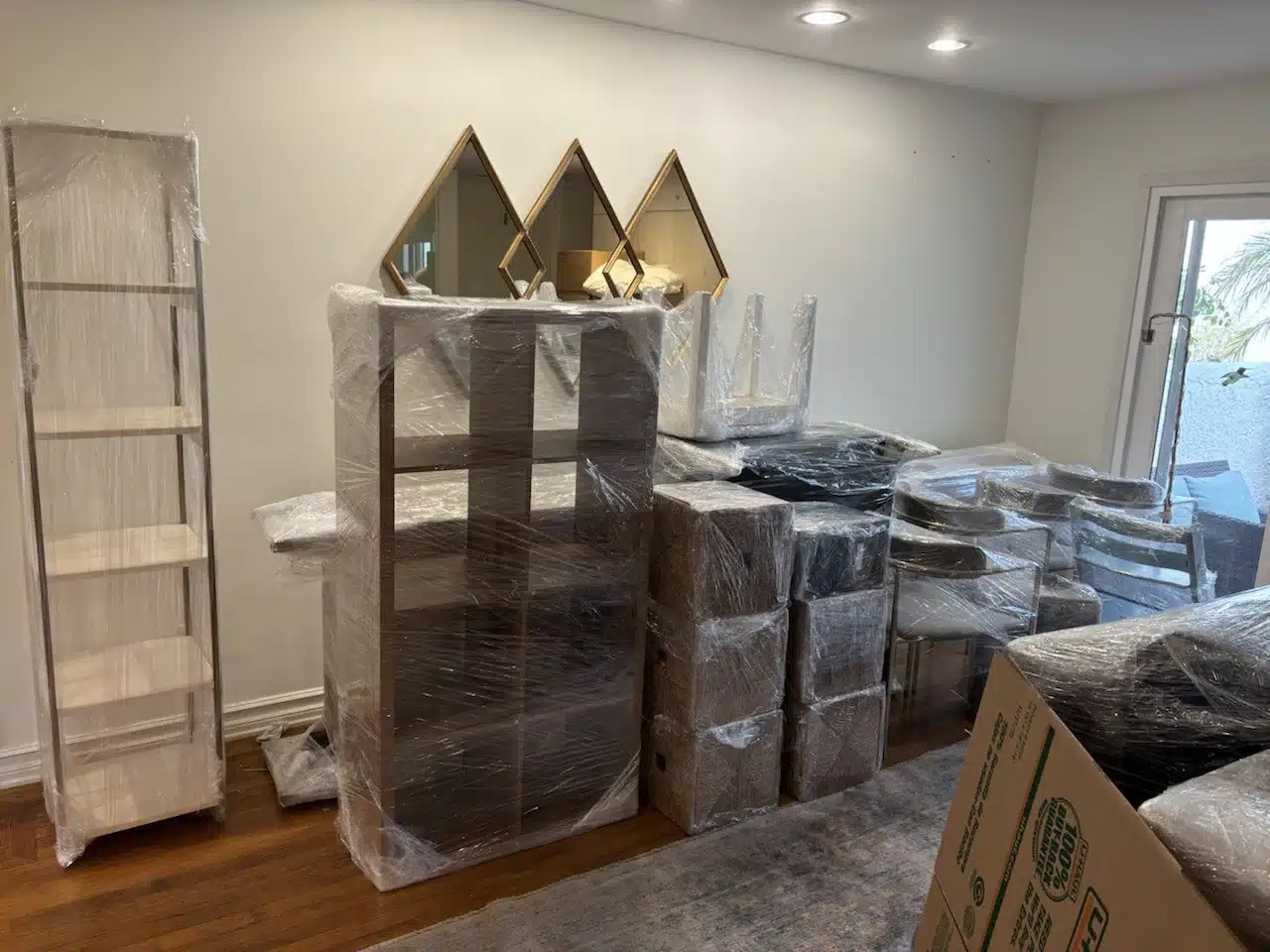 Packed and shrink-wrapped furniture staged inside a Rancho Palos Verdes, CA home before loading onto the moving truck.